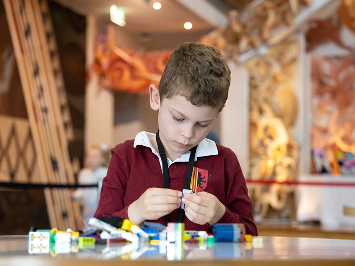 Autism NZ & LEGO Whānau Day 2021, 2021. Photo by Jo Moore. Te Papa (181759) A child is playing with Lego at a table in the Te Papa marae.