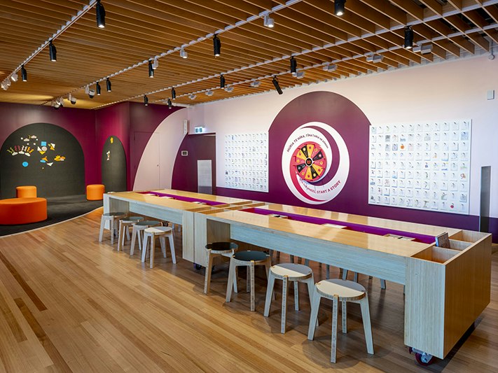 Papa Toi Art Studio. Photo by Maarten Holl. Te Papa (266552) Brightly coloured space with long tables and stools in the middle