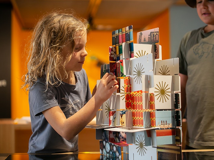 Te Aro School, Abstract Art and Passports, 2021. Photo by Jo Moore. Te Papa (171539) Two children are creating a tower out of cards.