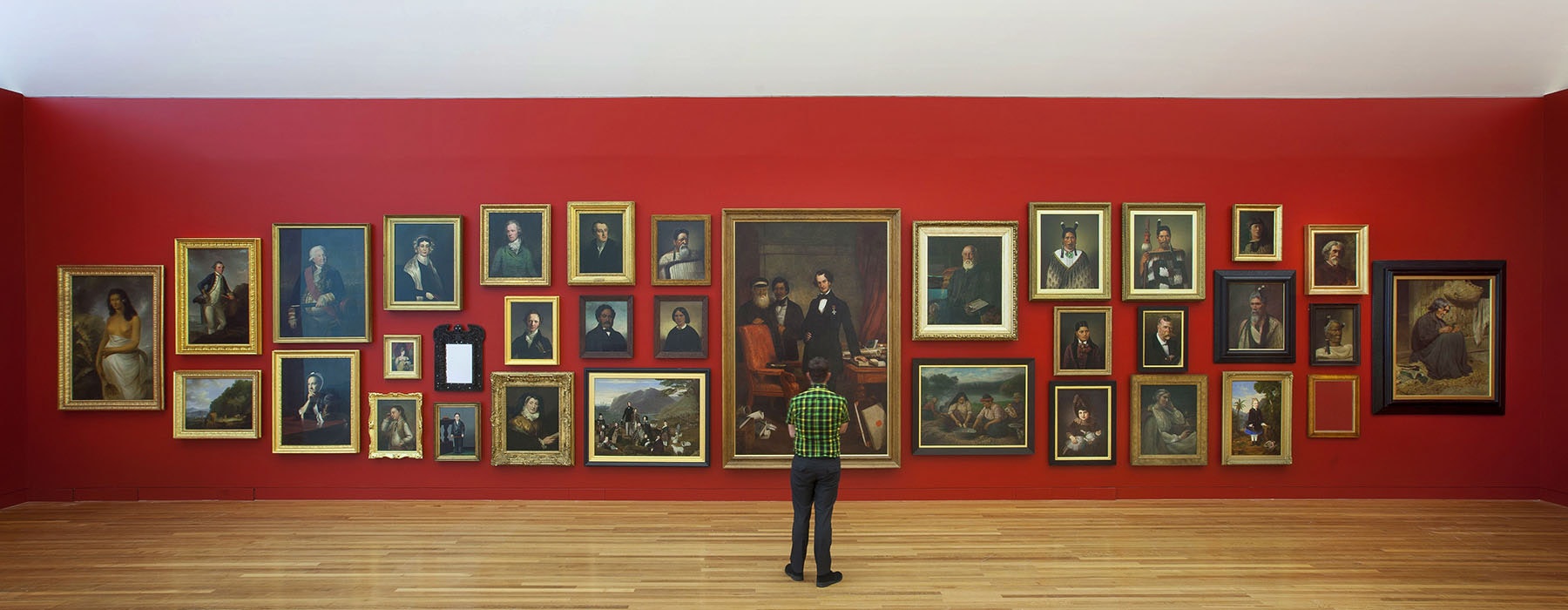 Man standing in front of a wall of portraits