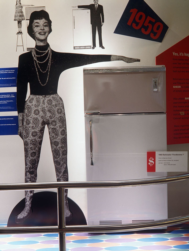 Refrigerator on display with a cardboard cutout of a woman next to it