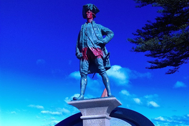 Statue of Captain James Cook with red paint on his face and across his abdomen