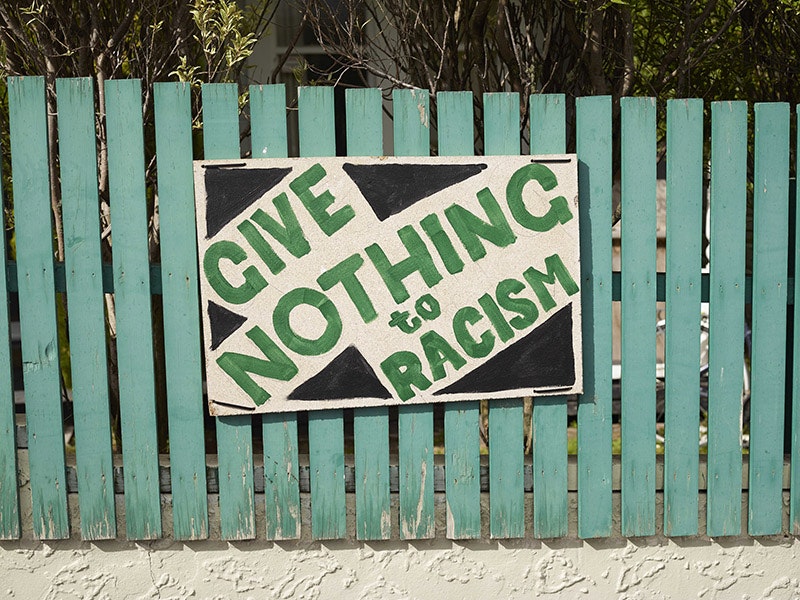 Give Nothing to Racism placard on fence, Constable Street, Newtown, Wellington, 26 Mar 2019, New Zealand, by Michael O'Neill. Field Collection, 2019. © Te Papa. CC BY-NC-ND 4.0. Te Papa (CA001228/001/0021) Green fence with a hand-painted sign on it saying, 'Give nothing to racism' in green and black.