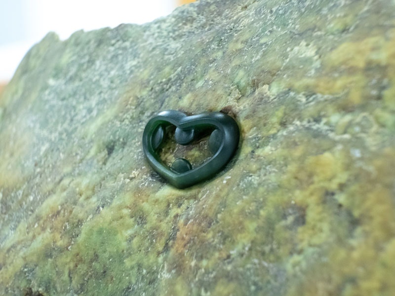 A greenstone carved into an abstract heart shape