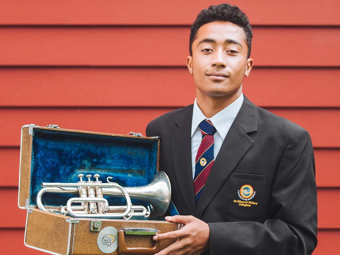 A student stand with a trumpet in a box