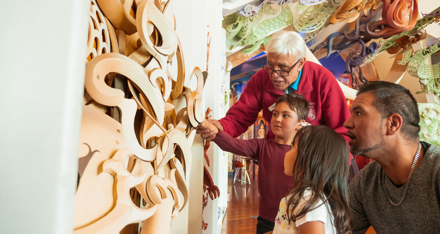 Children looking at carvings on a wharenui (large meeting house)