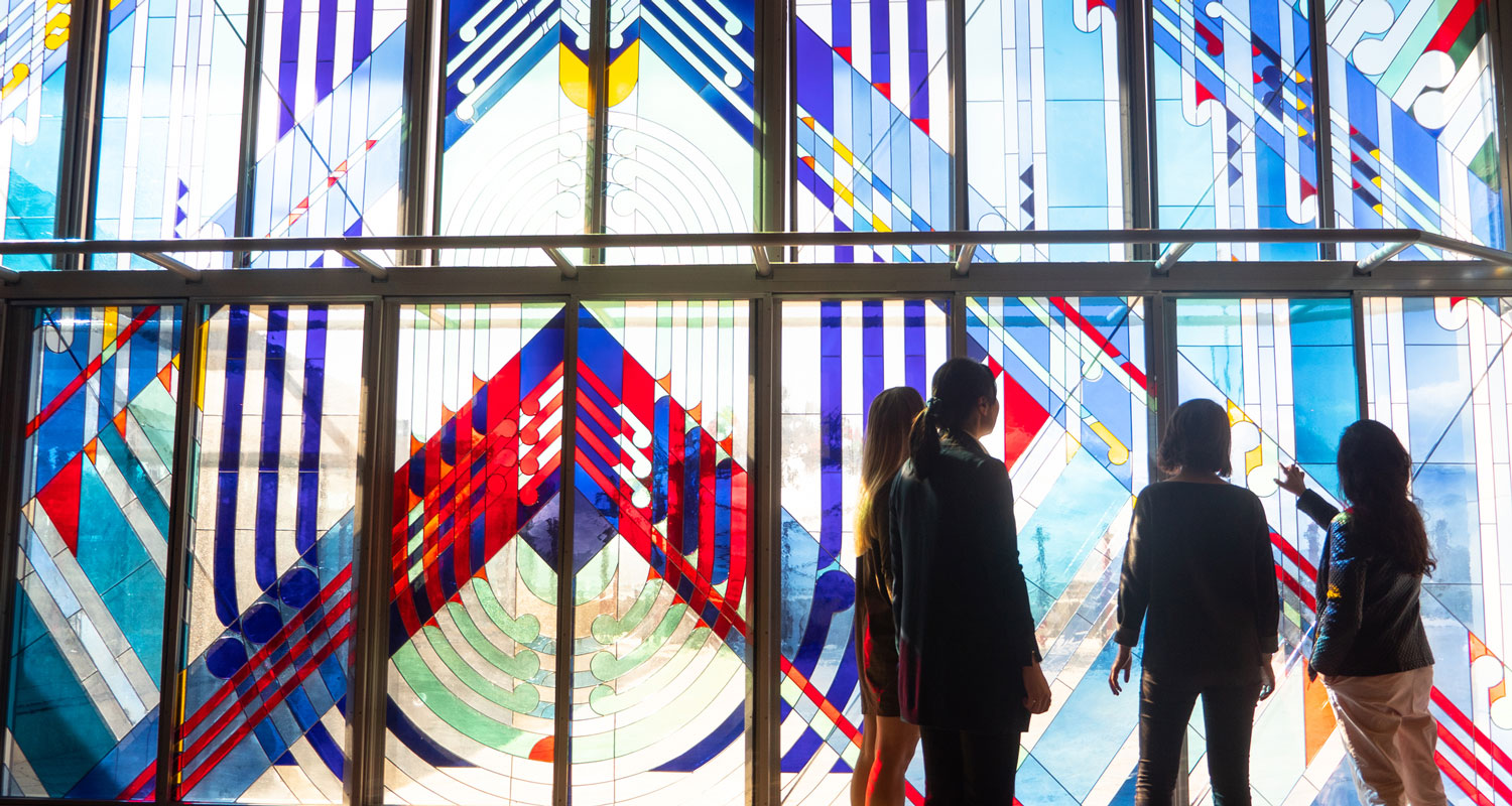 People looking at stained-glass windows