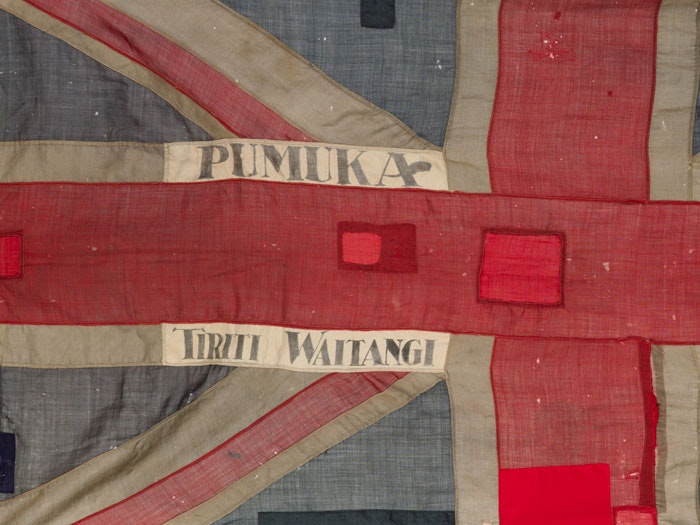 A Union Jack flag with the words Pumuka and Tiriti Waitangi embroidered on