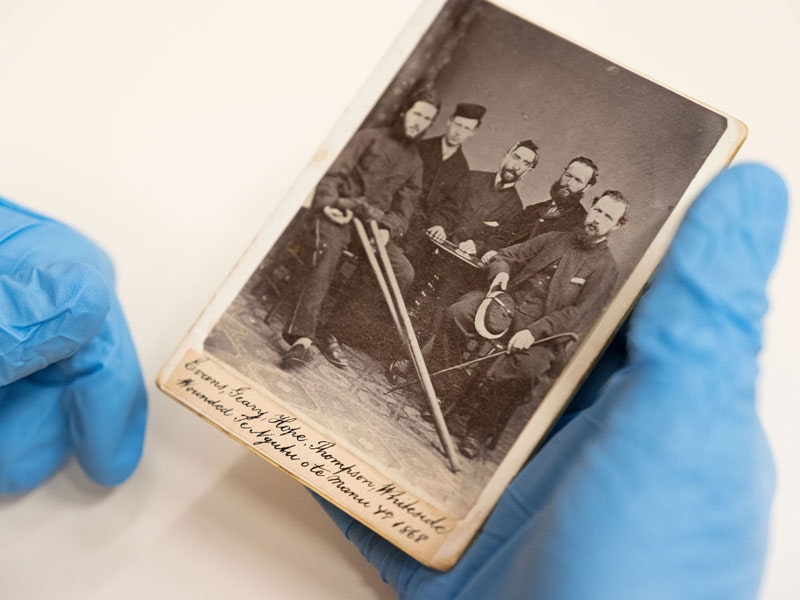 Caring for photographs, 2018. Te Papa Someone is blue gloves holding an old photograph
