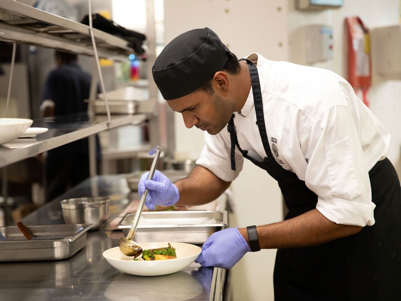 A chef puts the finishing touches to a dish