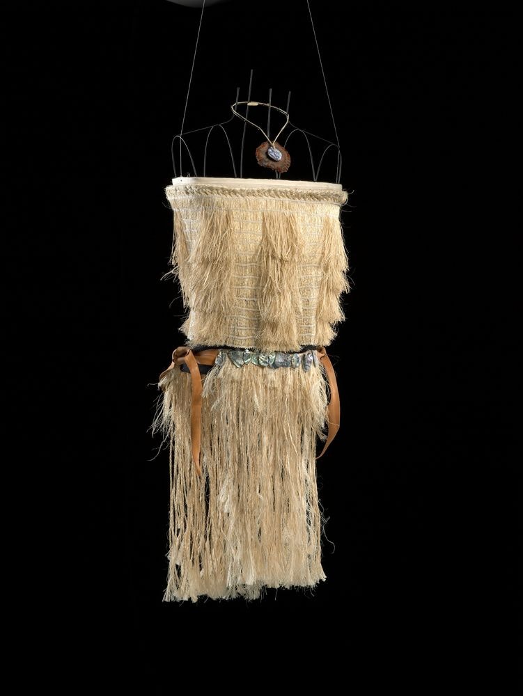A woven bodice with shoulder straps and a woven skirt on a wire frame on a black background.