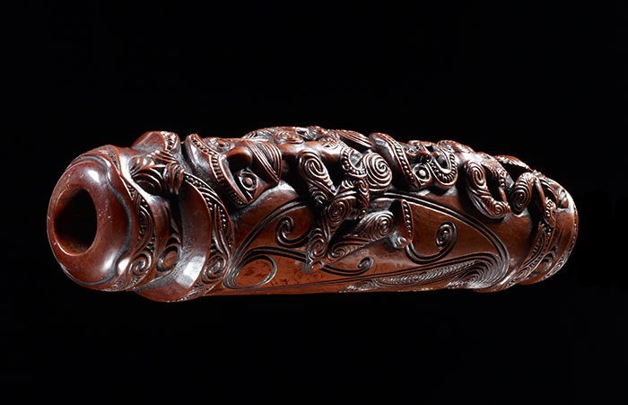 Carved bone flute in a dark red colour