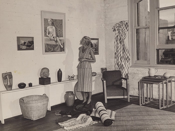 Helen Hitchings inspecting a self-portrait on display in her gallery