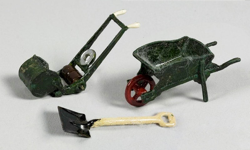 Miniature spade, wheelbarrow, and lawn mower.