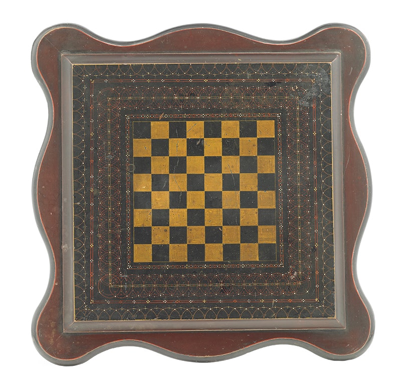 Wooden games table with a draft/chess board on top. Curved edges and an intricately painted border.