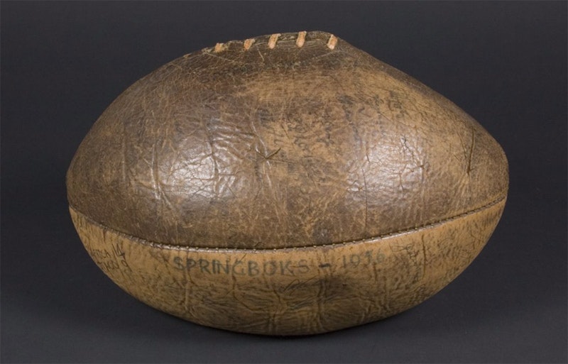 brown leather rugby ball with ink signatures on it