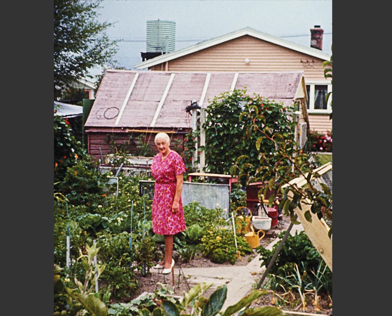 Photograph of a woman standing in her vegetable garden by FR Lamb