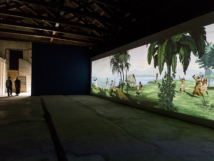 Two people look at Lisa Reihana's Emissaries artwork displayed at Venice Biennale