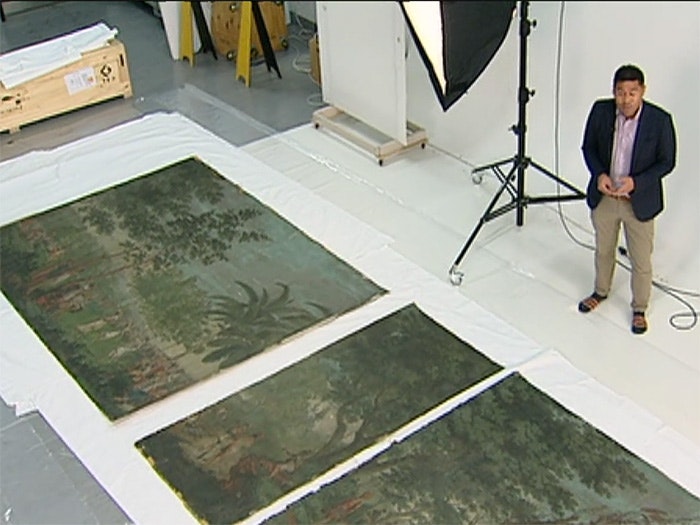 A news reporter stands by the Dufour wallpaper