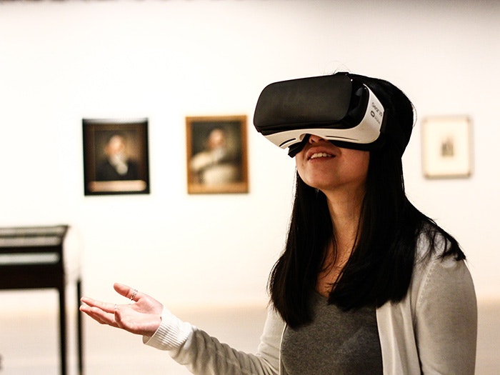 A woman wears a VR headset in an art gallery