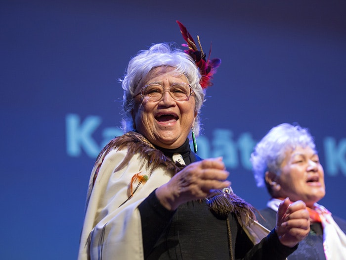 A lady in a Māori cloak sings
