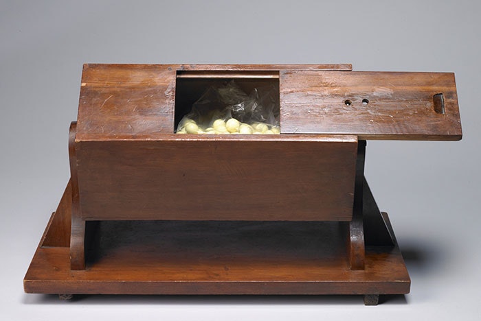 Wooden ballot box with its door open to show the balls inside