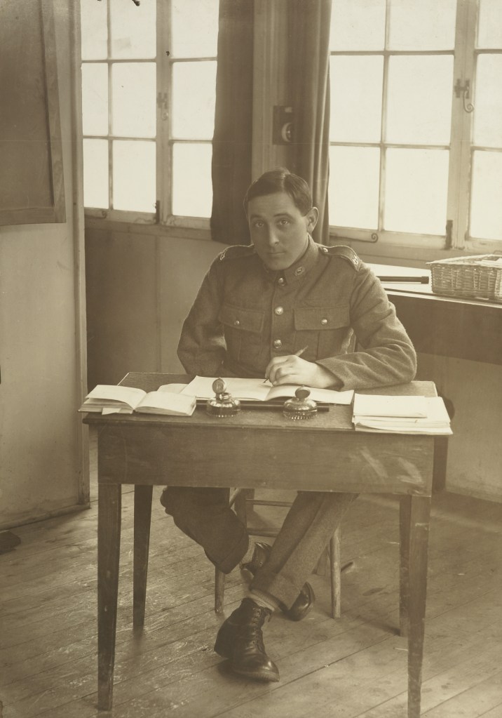 Portrait of an unidentified WWI soldier, right arm amputated, seated at a desk