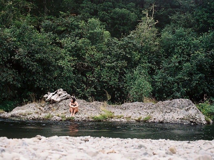Woman sits on a riverbed