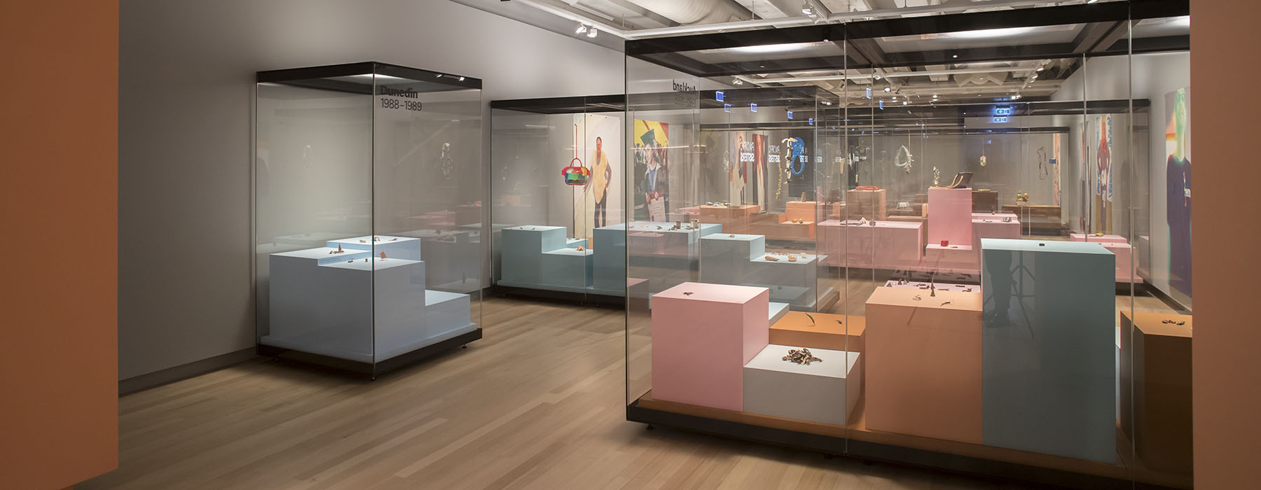 View of Lisa Walker’s exhibition including multiple cabinets filled with colourful plinths and jewellery on them