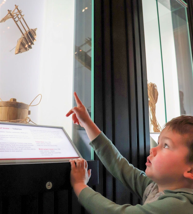 Little boy points to a model vaka in an exhibition