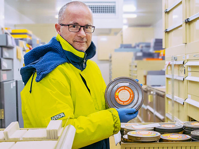 David Riley in the cold store holding one of the film archives