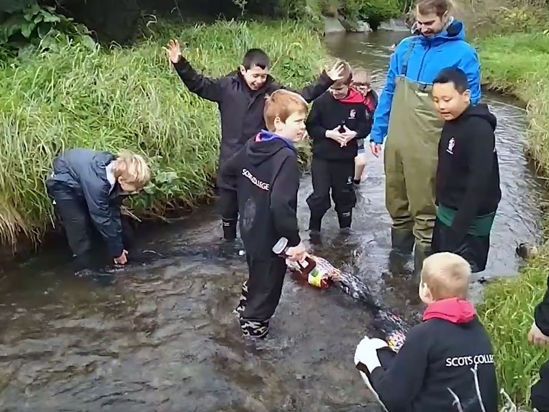 School kids cleaning a river of plastic