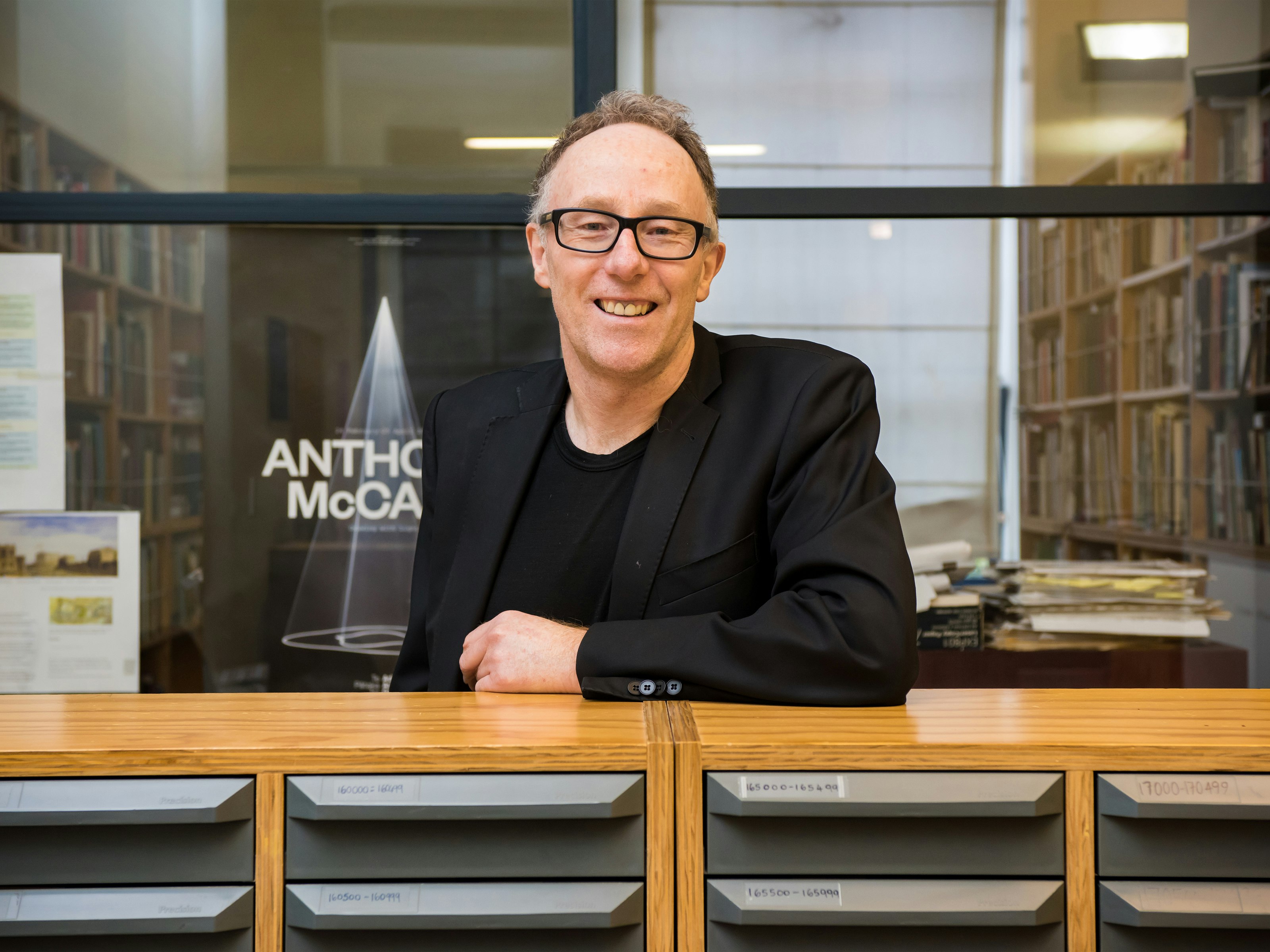 Conal McCarthy, author of Te Papa: Reinventing New Zealand's national museum 1998–2018 A man leaning on a filing cabinet and smiling at the camera
