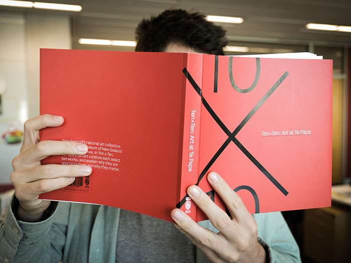 Man holds a copy of the book up