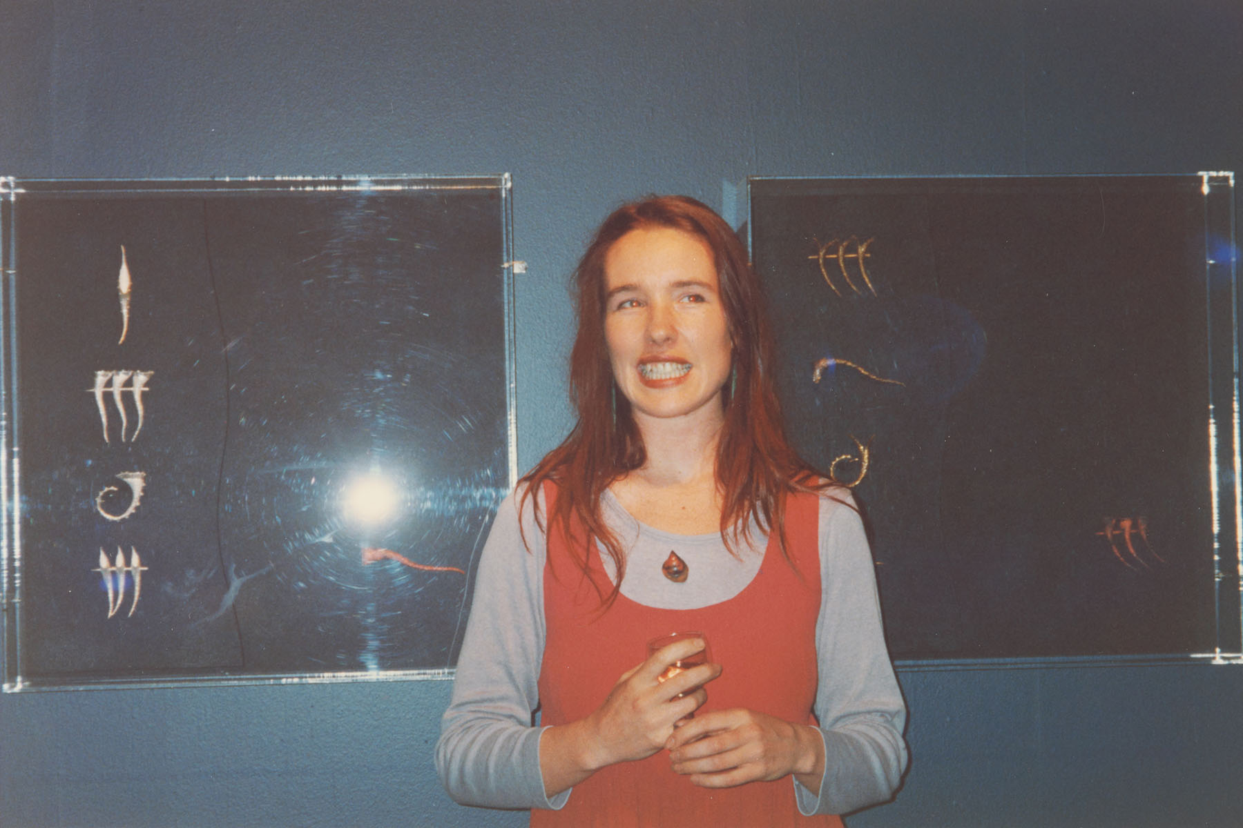 Lisa stands in front of her work displayed on a gallery wall