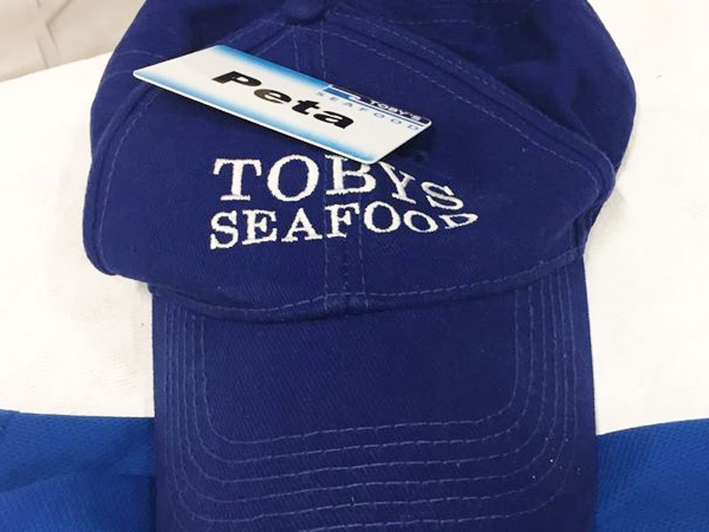 Blue cap with the words 'Toby's Seafood' stitched in white