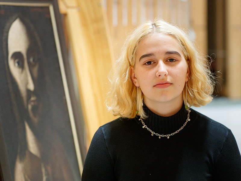 Aroha Millar in front of Tony Fomison, Salvator mundi, 1970, oil on hessian on board. Te Papa (1993-0018-1). Photo by Kate Whitley, 2018. Te Papa =""