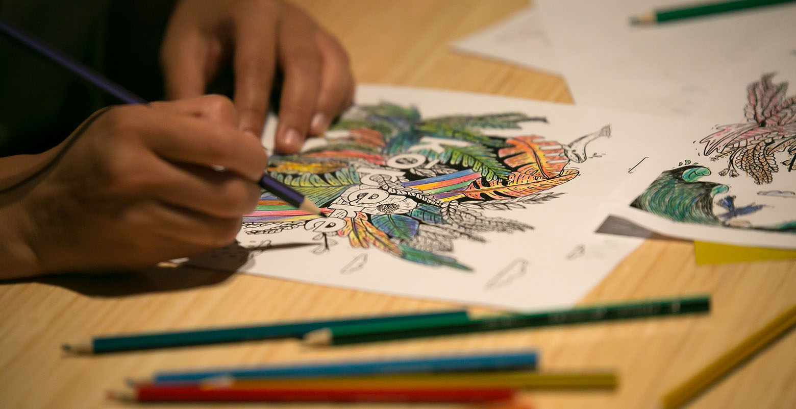 Close-up of a child's hands while they draw on a sheet of paper