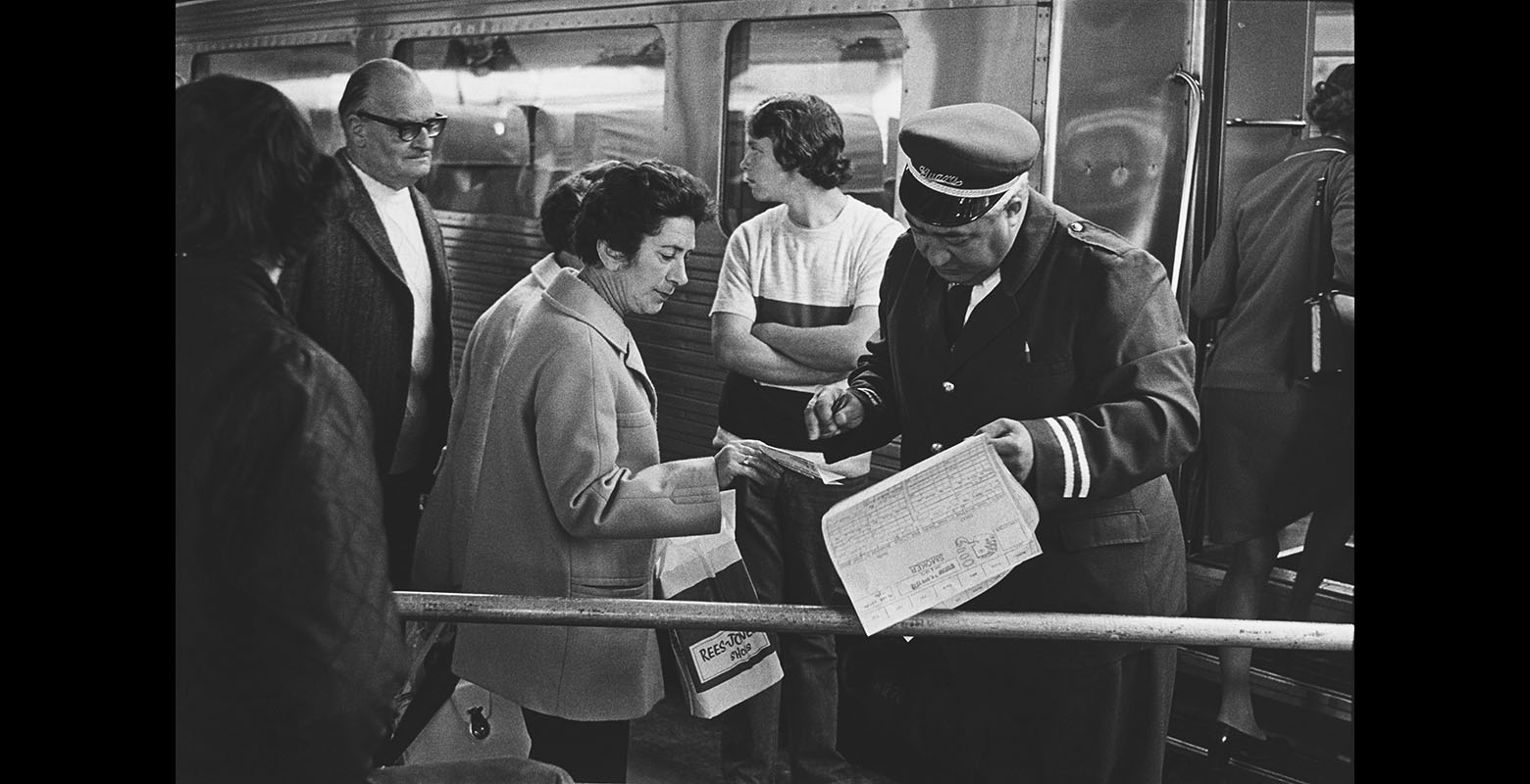 A man checks a ticket of a woman at a train station