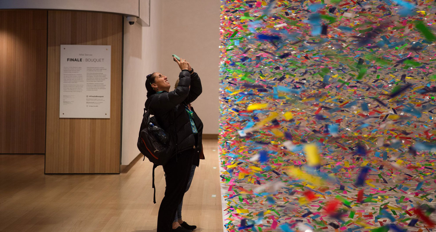 Visitor taking photos of a colourful large-scale artwork