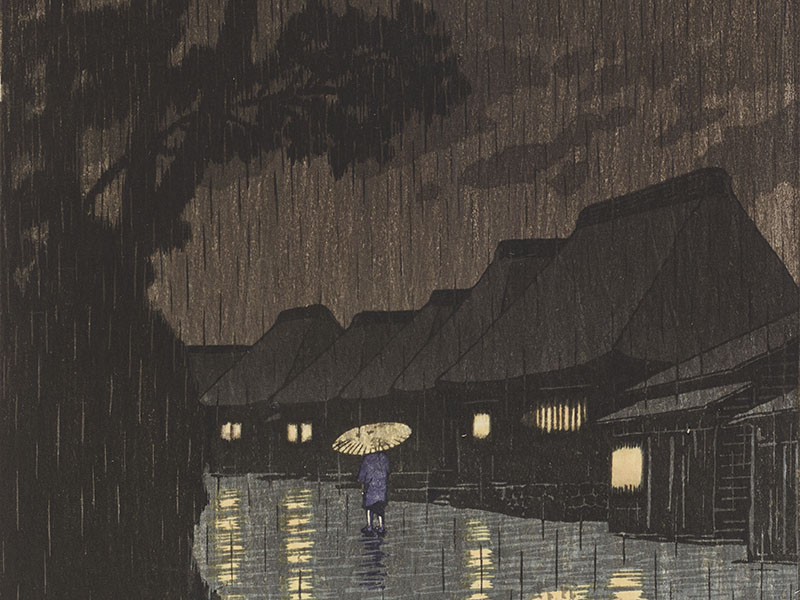 Person walks down a path in heavy rain, flanked by very tall trees on the left and houses with their lights on to the right