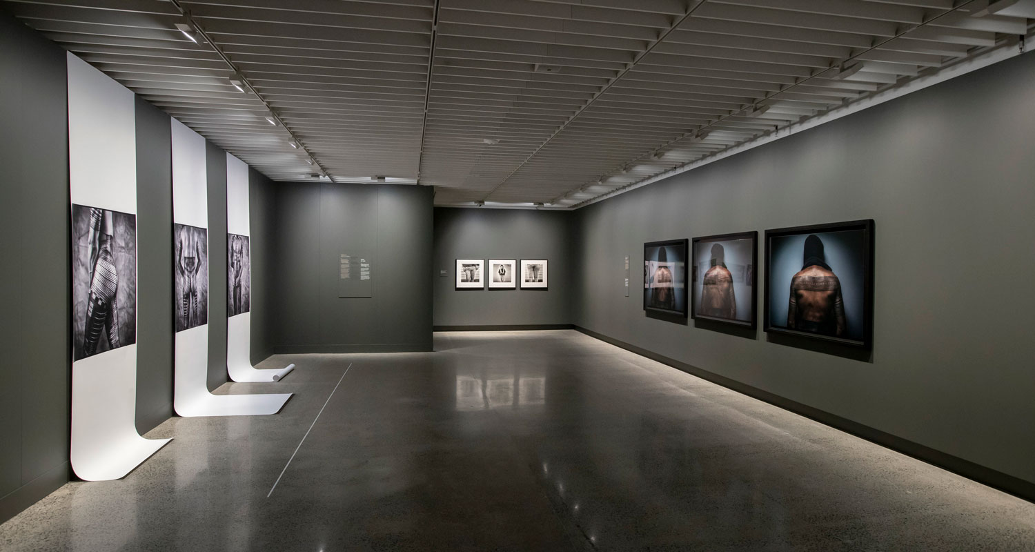 View of a gallery, photos of tattooed people on the walls