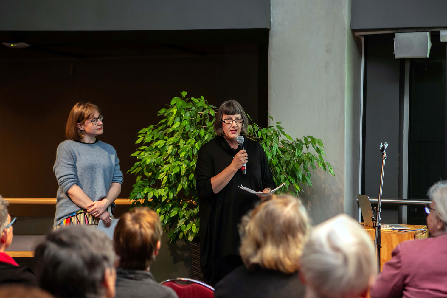 Two ladies presenting to a crowd