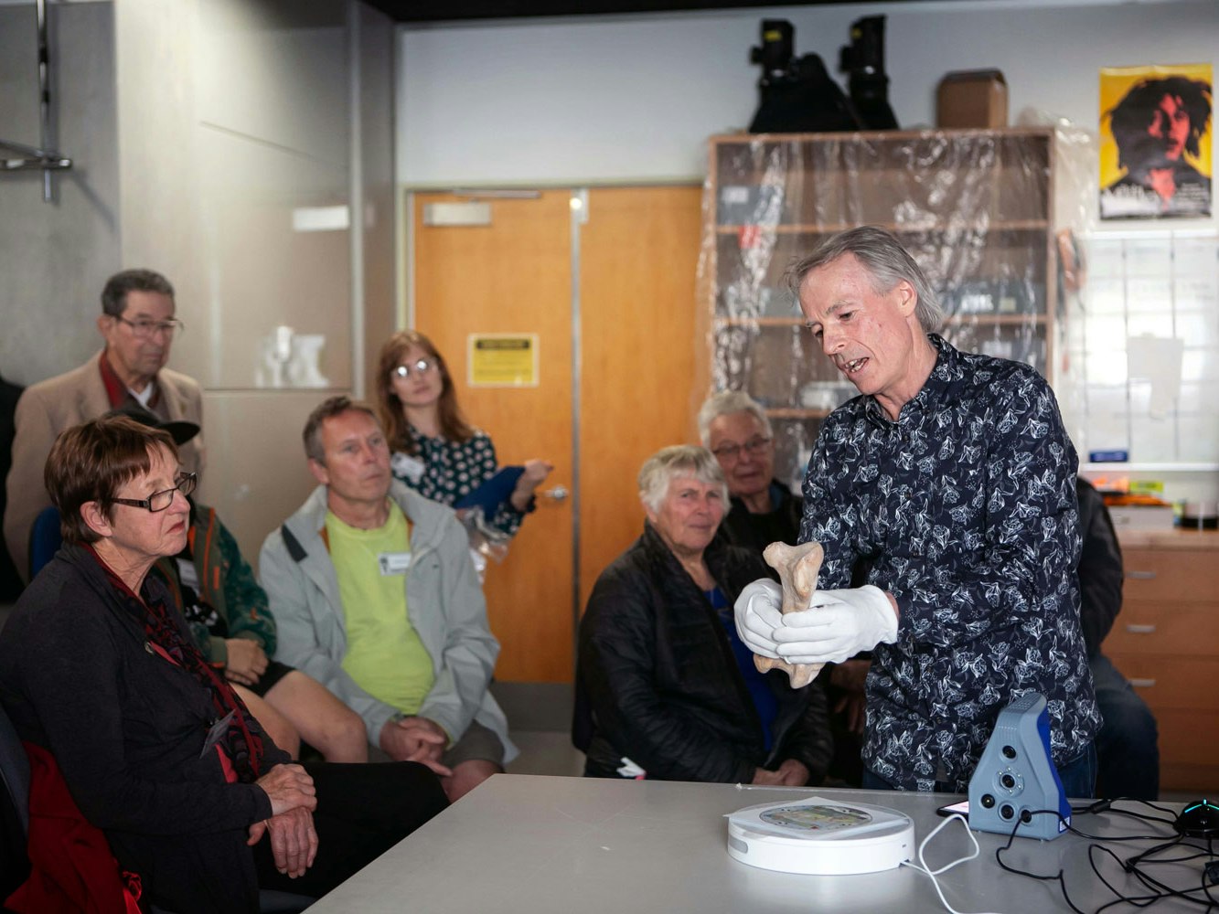 tour-friends-imaging-tepapa-1500x1000.jpg A man in front of a crowd holds a moa bone