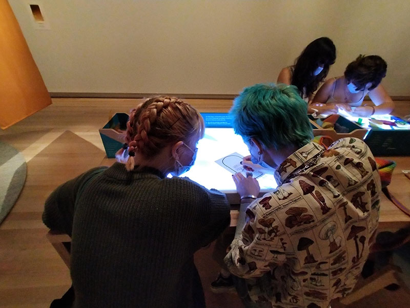 Young people sitting in a room drawing