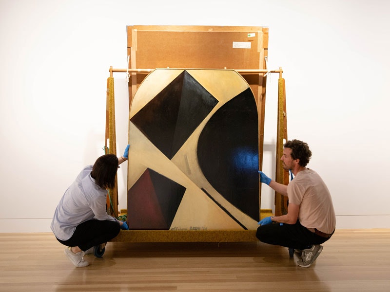Two people install an artwork