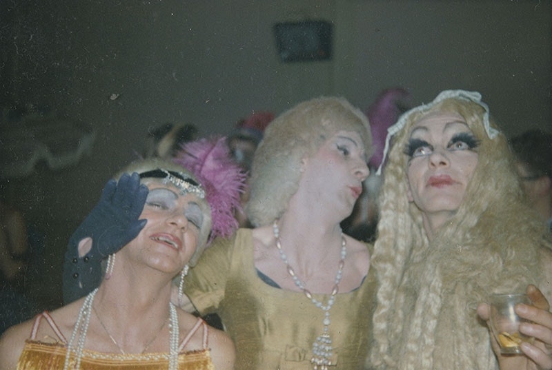 Close up of three people in costume posing in a jovial manner