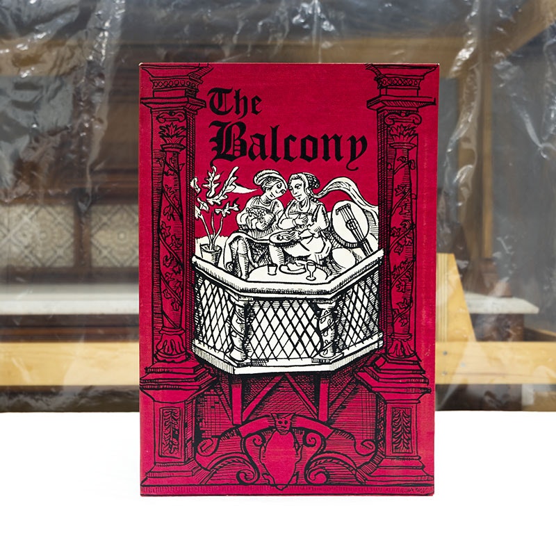 Print red print featuring black linocut-style Medieval drawing of two people sitting on a balcony
