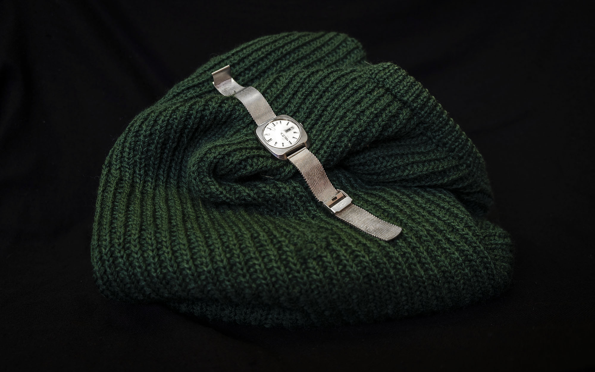 Green knitted jumper and a silver watch