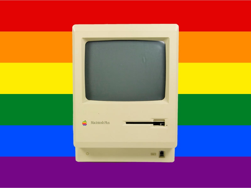 Photo of Apple Macintosh computer monitor over top of a rainbo flag
